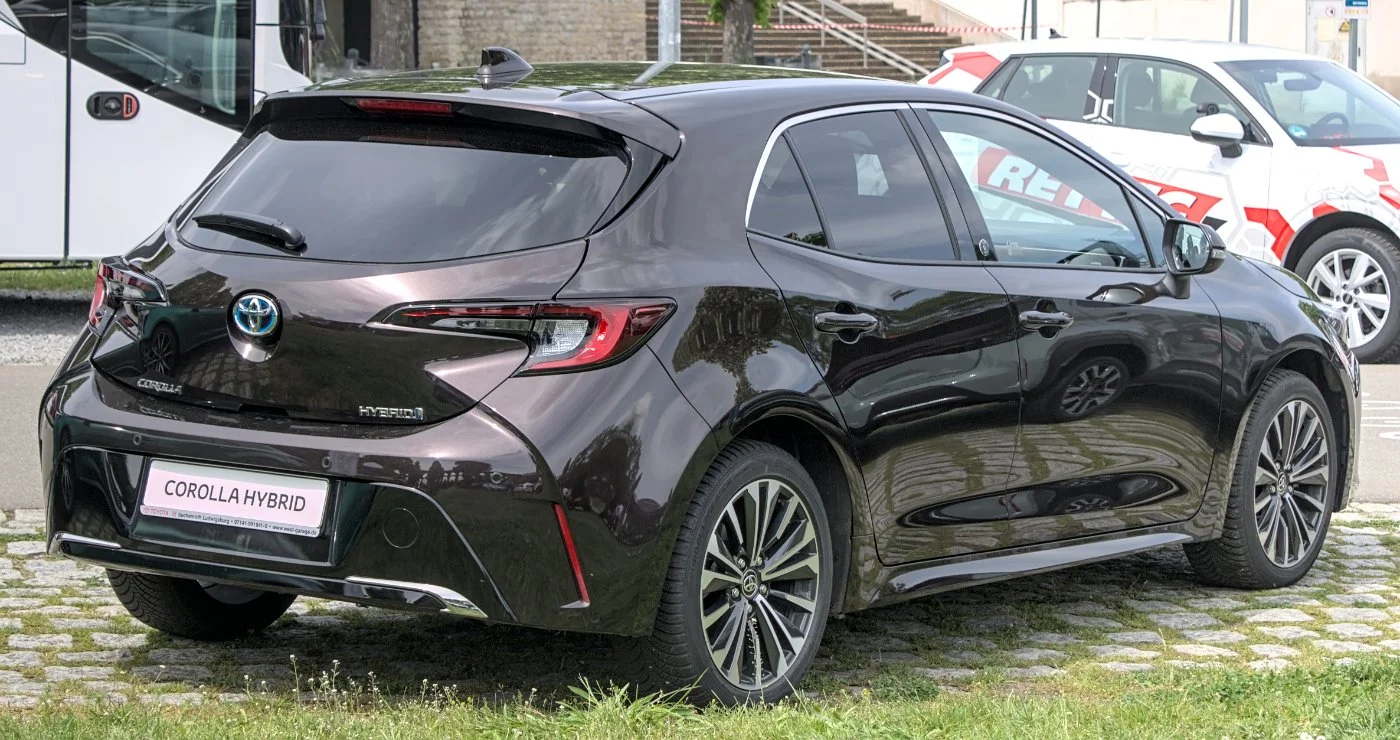 Toyota Corolla Hybrid hatchback side profile on a rural road